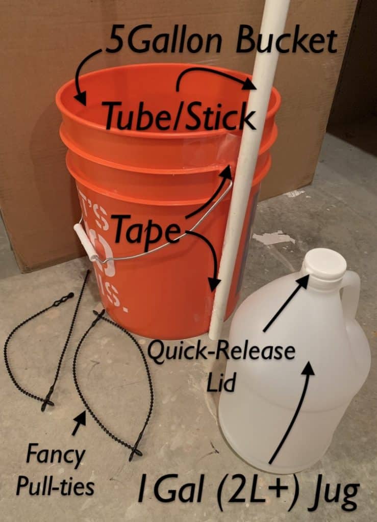 orange five gallon bucket with white tube taped to the side in front of a cardboard box